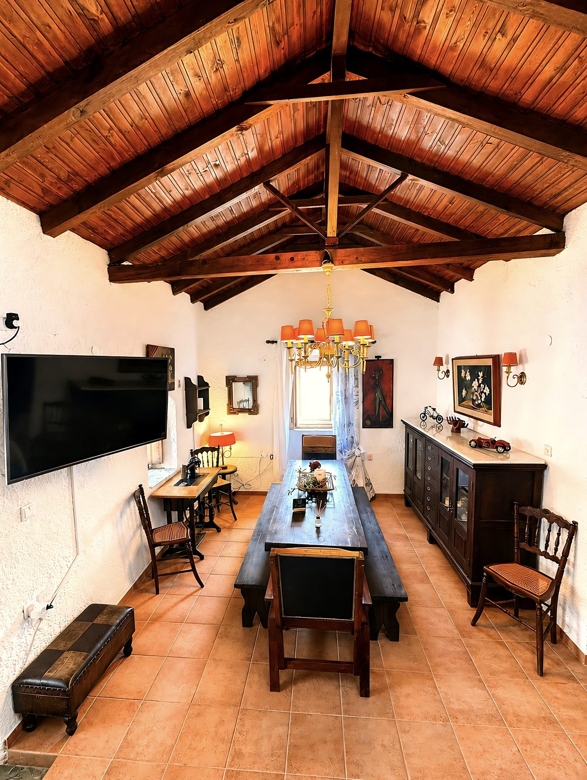 Living room with a long wooden table and vaulted timber ceiling