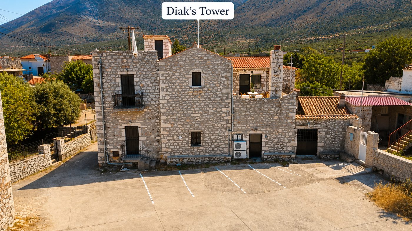 Diak's Tower, stone tower façade with the mountains of Mani behind